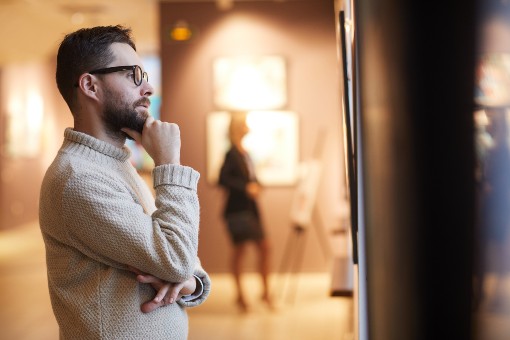 Photo représentant un homme qui regarde une œuvre d’art dans un musée